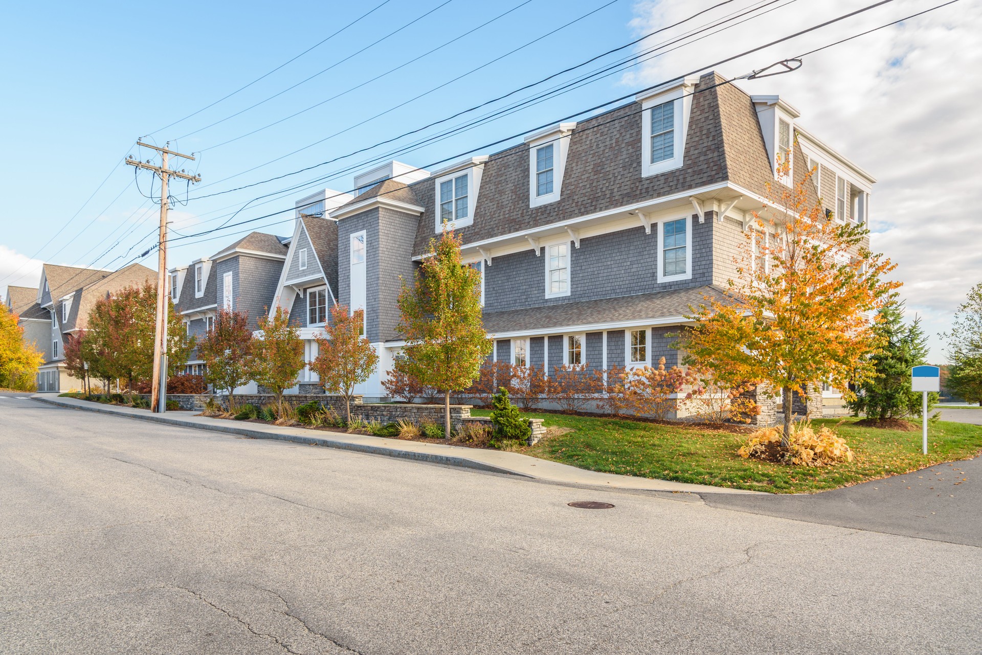 Modern apartment buildings along a street in a new development on a sunny autumn day